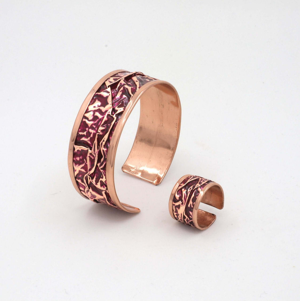 Handcrafted magenta wrinkled copper jewellery set displayed on a plain background