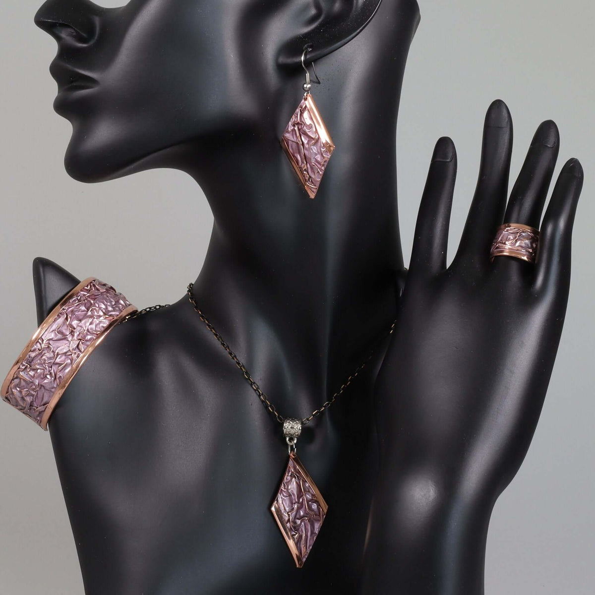 Pink wrinkled copper jewellery set in style 01 displayed on a plain background