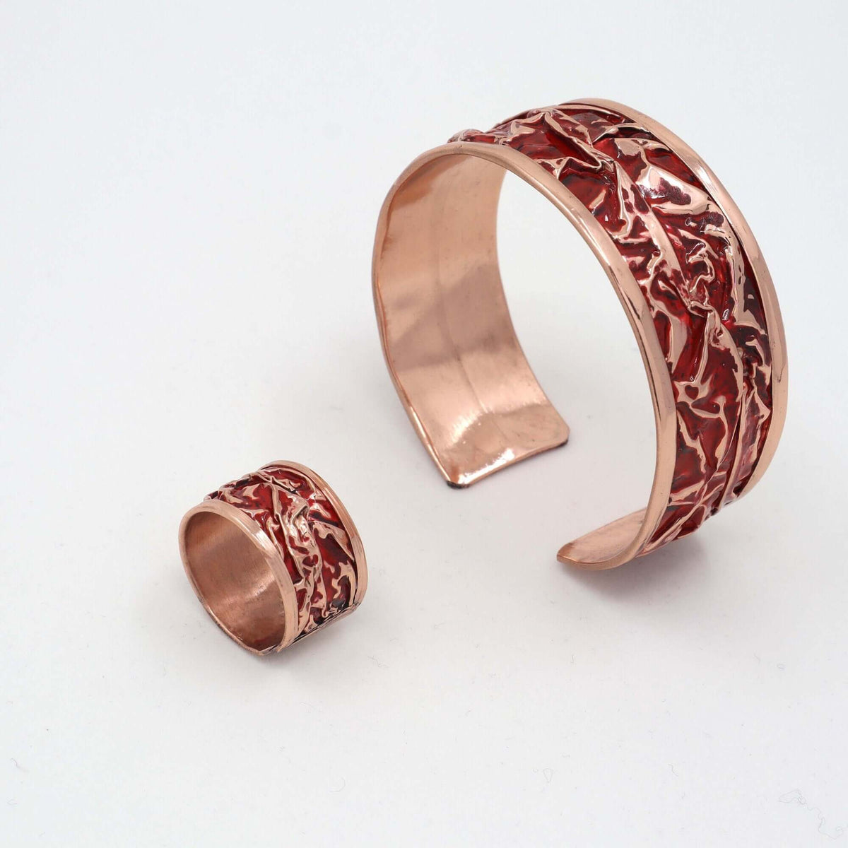 Four-piece red patterned wrinkled copper jewellery set displayed on a plain background
