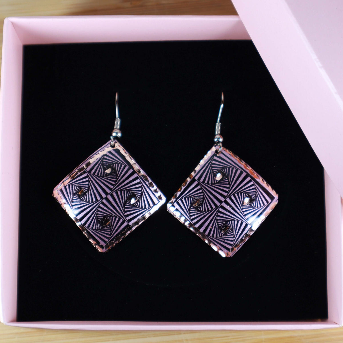 Side angle of artisan purple geometric copper square earrings