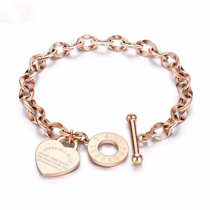 Heart charm chain bracelet with a steel toggle clasp shown next to a hand for scale