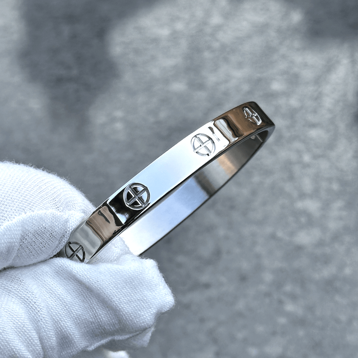 Stainless steel couple bangle bracelet set in 6mm and 8mm shown next to a hand for scale