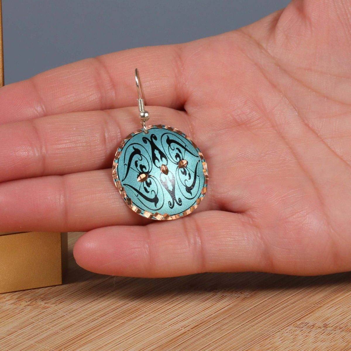 Top-down view of handcrafted artisan green copper circle earrings