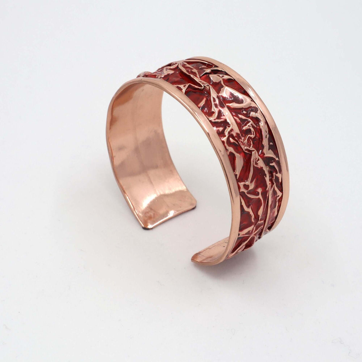 Angled view of four-piece red patterned wrinkled copper jewellery set