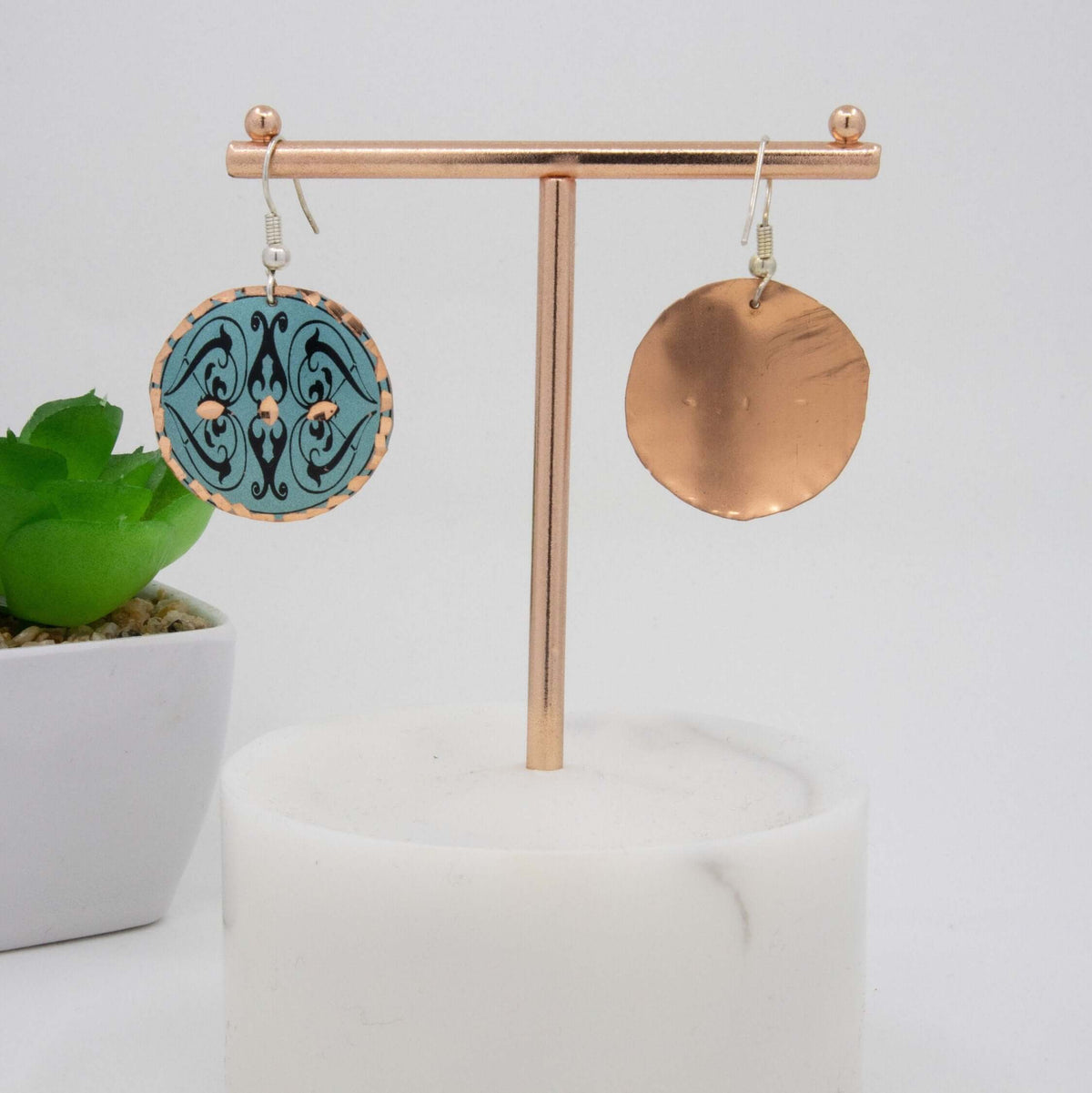 Side angle of handcrafted artisan green copper circle earrings