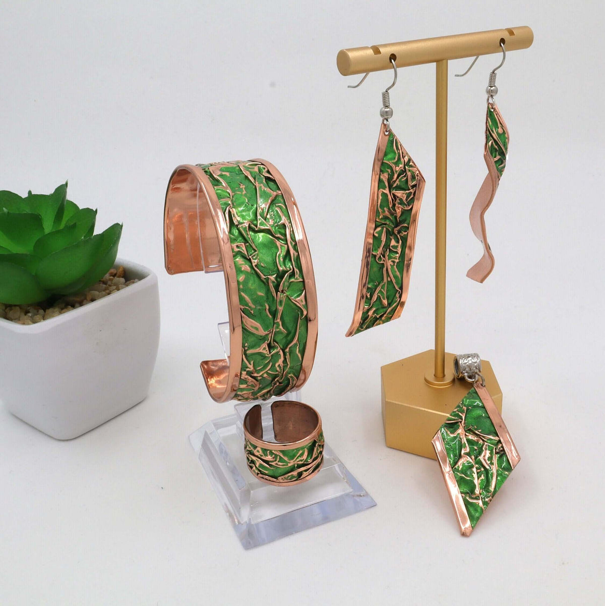 Individual pieces from complete green wrinkled copper jewellery set arranged together