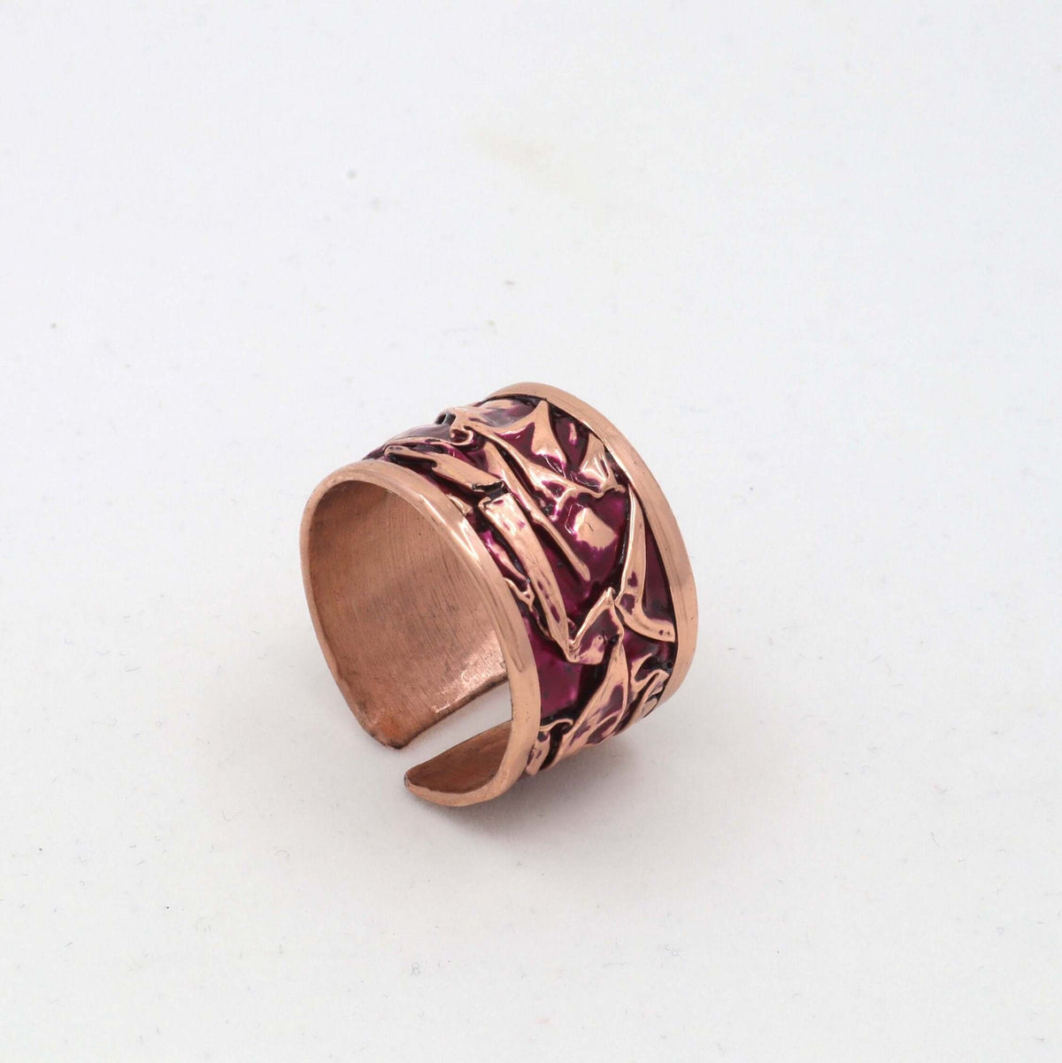 Top-down view of handmade magenta wrinkled copper adjustable ring