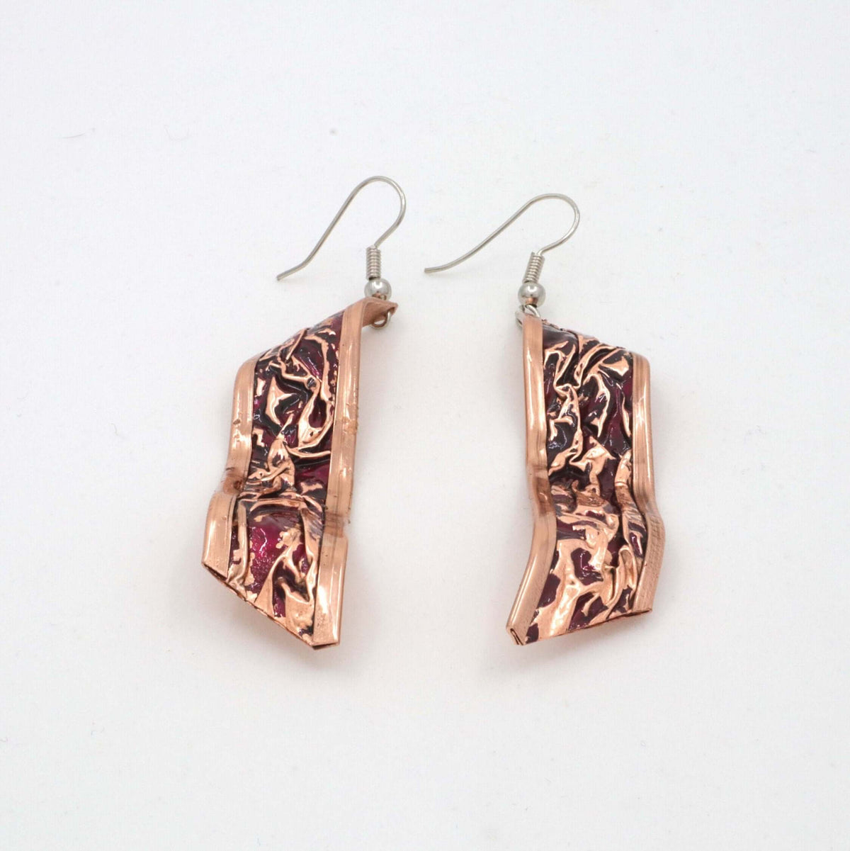 Top-down view of handcrafted magenta wrinkled copper jewellery set