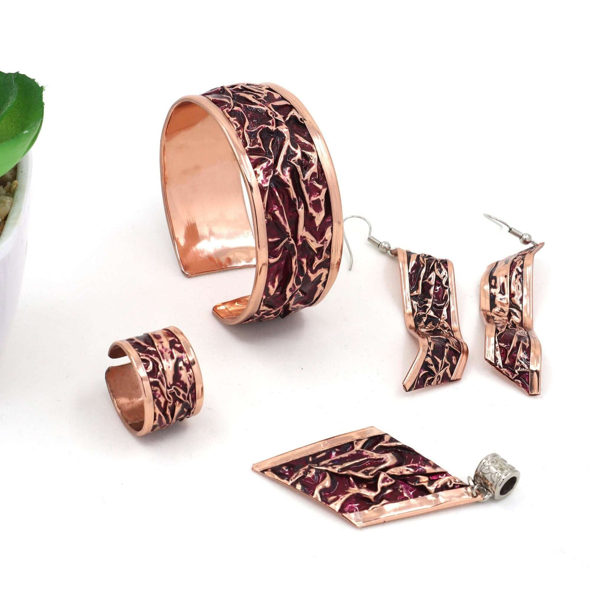Side angle of handcrafted magenta wrinkled copper jewellery set