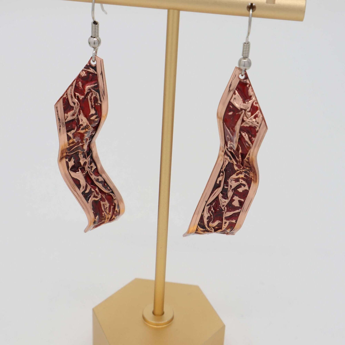 Top-down view of four-piece red patterned wrinkled copper jewellery set