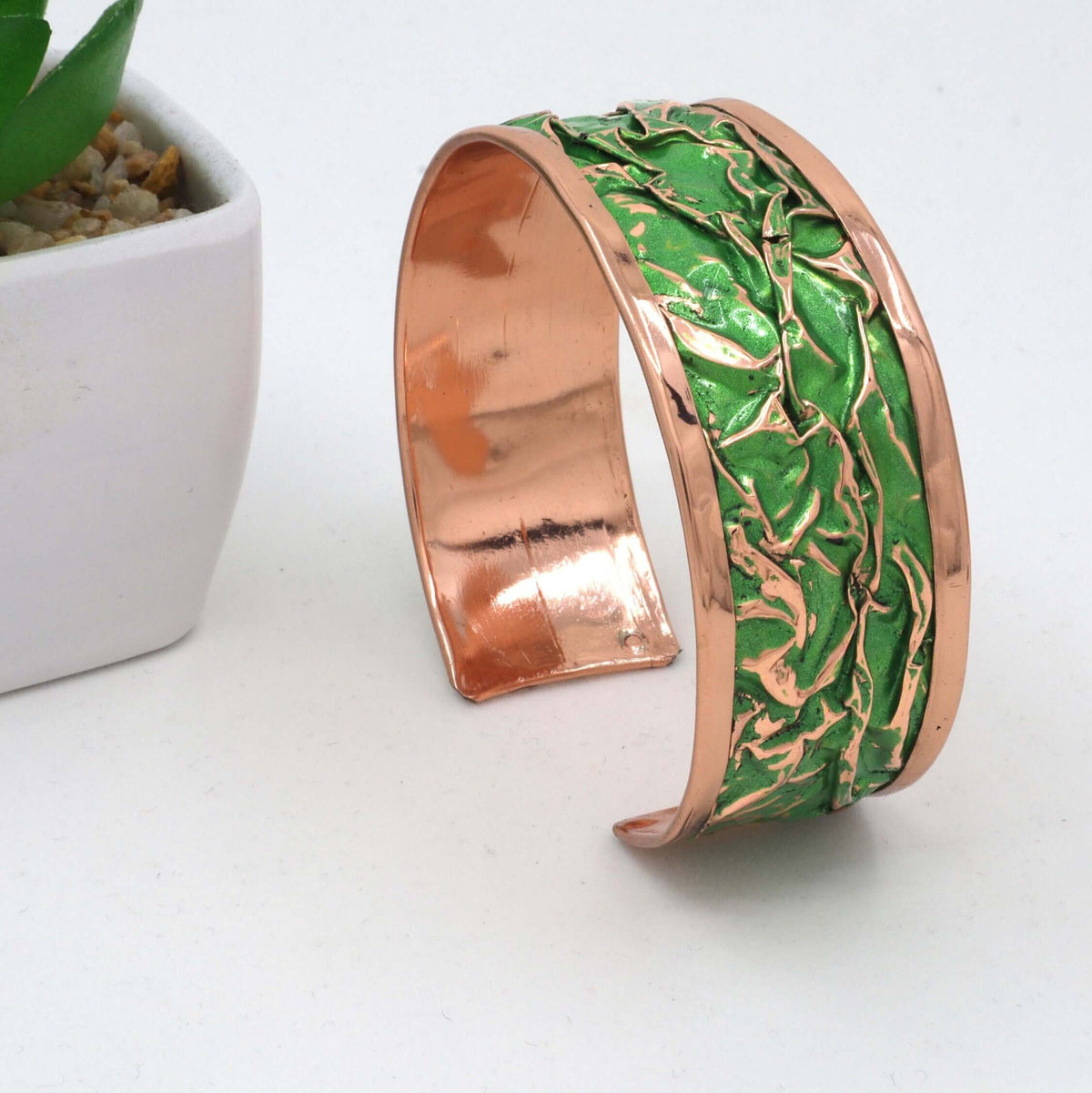 Complete green wrinkled copper jewellery set shown next to a hand for scale