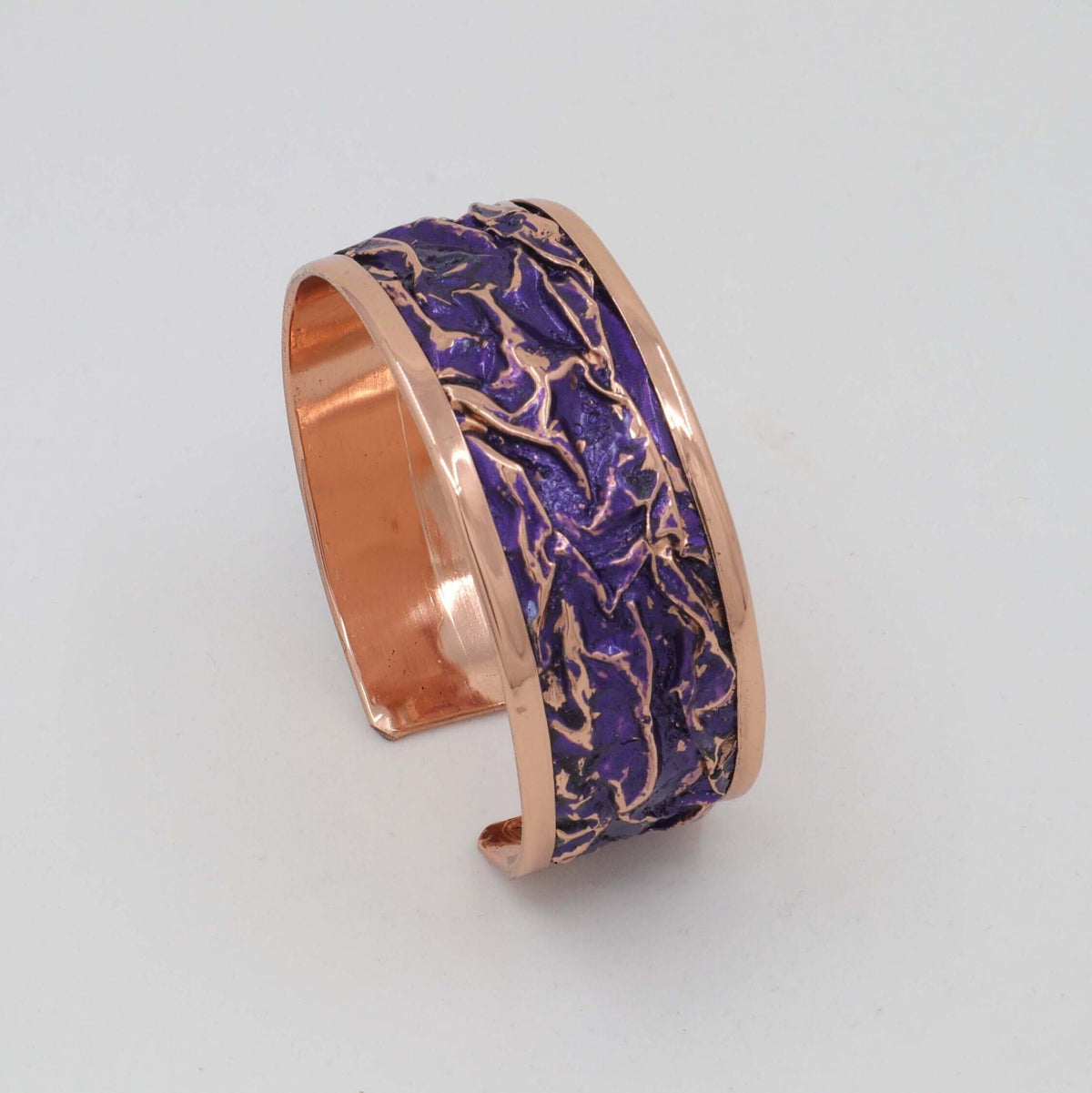 Top-down view of four-piece purple wrinkled copper jewellery set