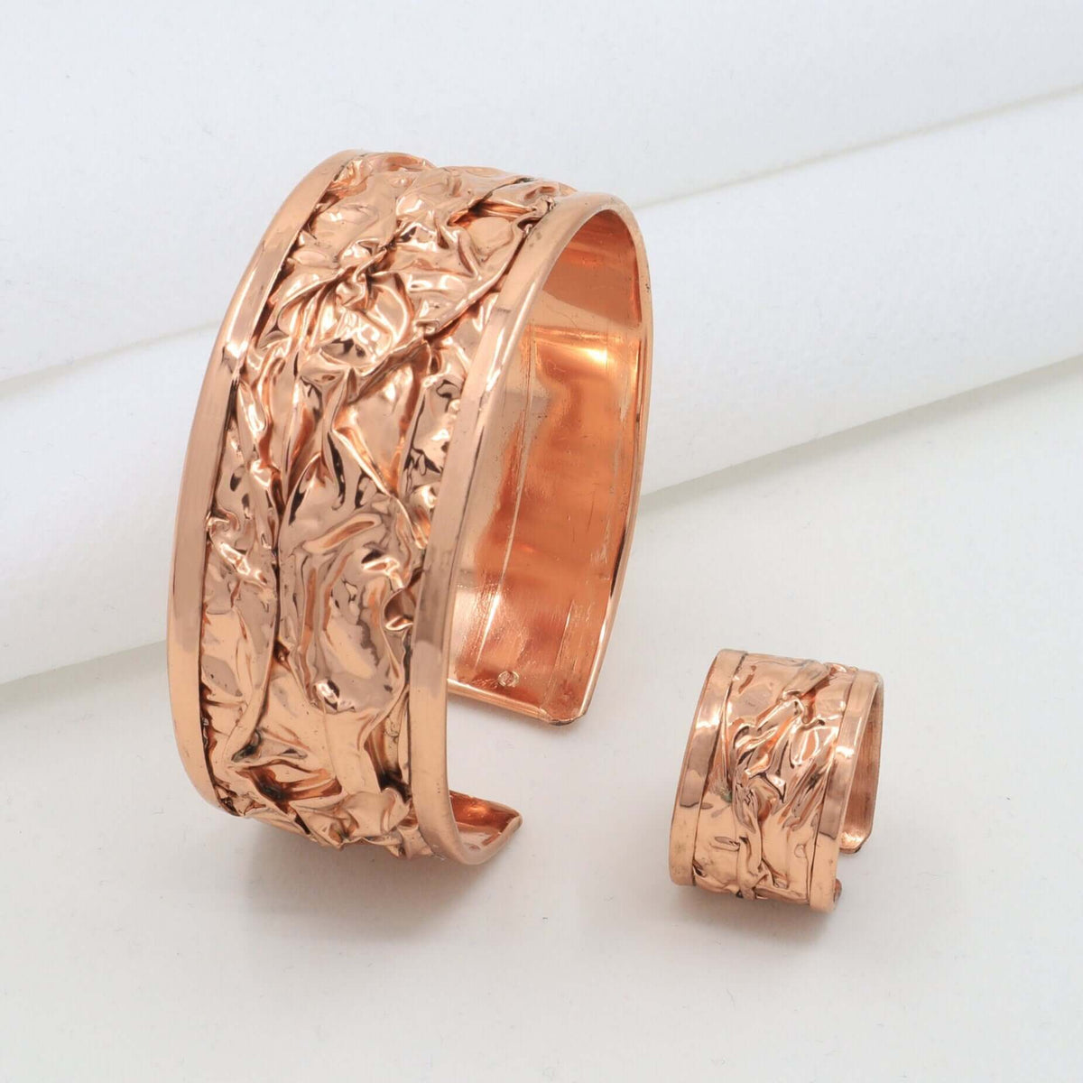 Individual pieces from handcrafted wrinkled copper jewellery set arranged together