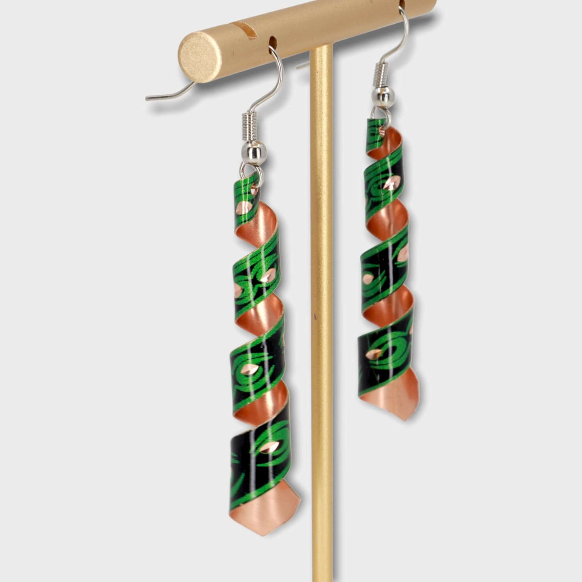 A pair of handcrafted artisan green auger copper earrings laid flat