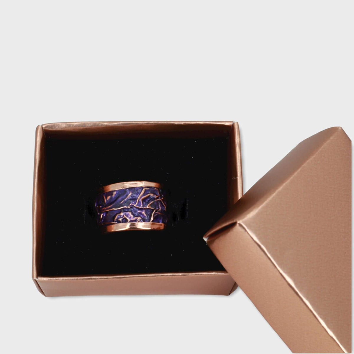 Top-down view of purple wrinkled copper adjustable ring