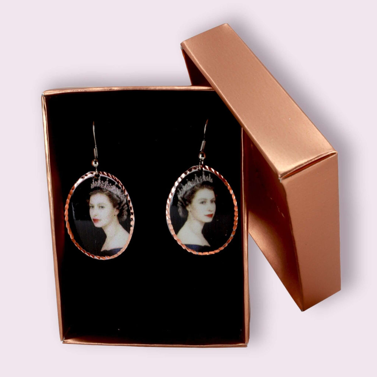 Side angle of artisan Queen Elizabeth II copper oval earrings