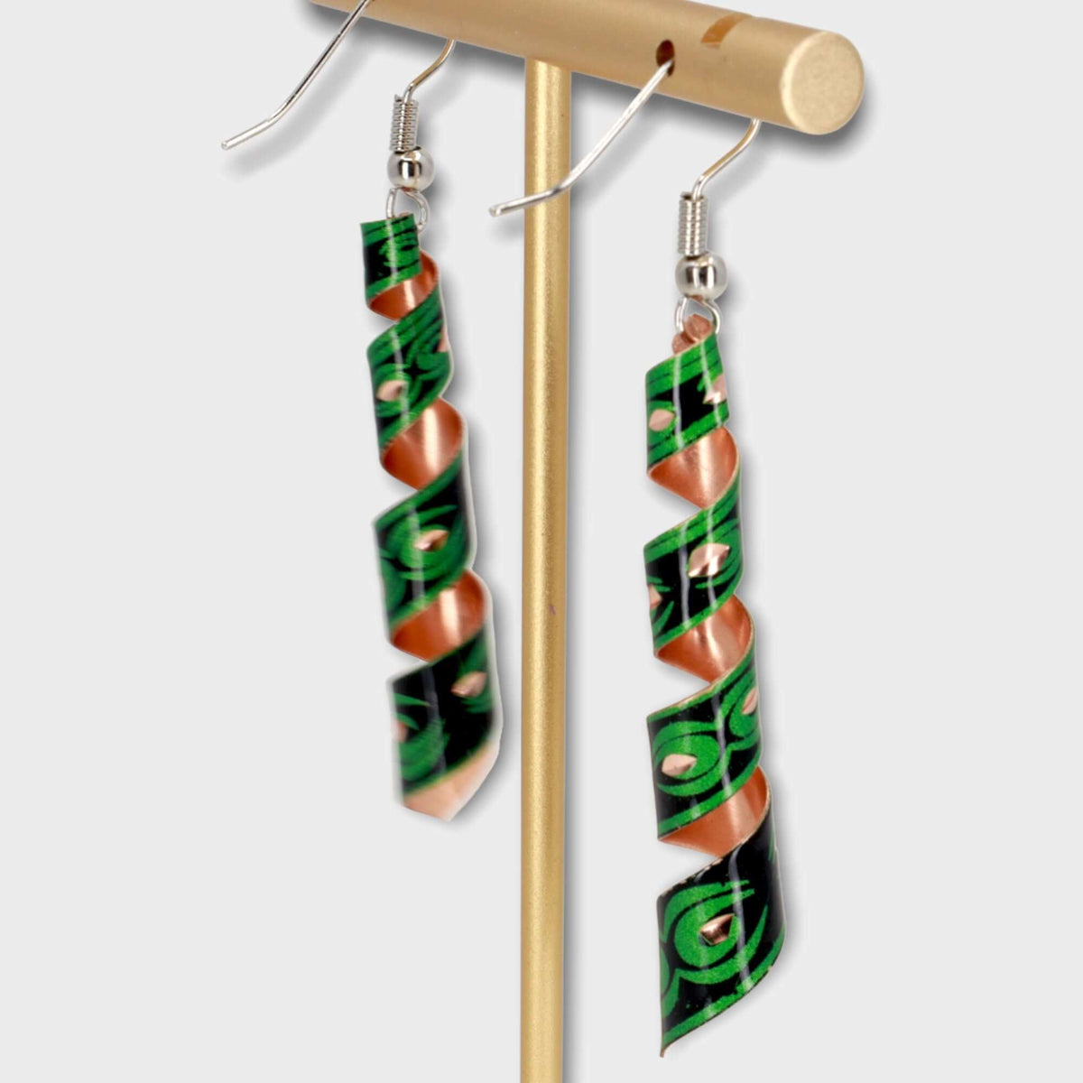 Top-down view of handcrafted artisan green auger copper earrings