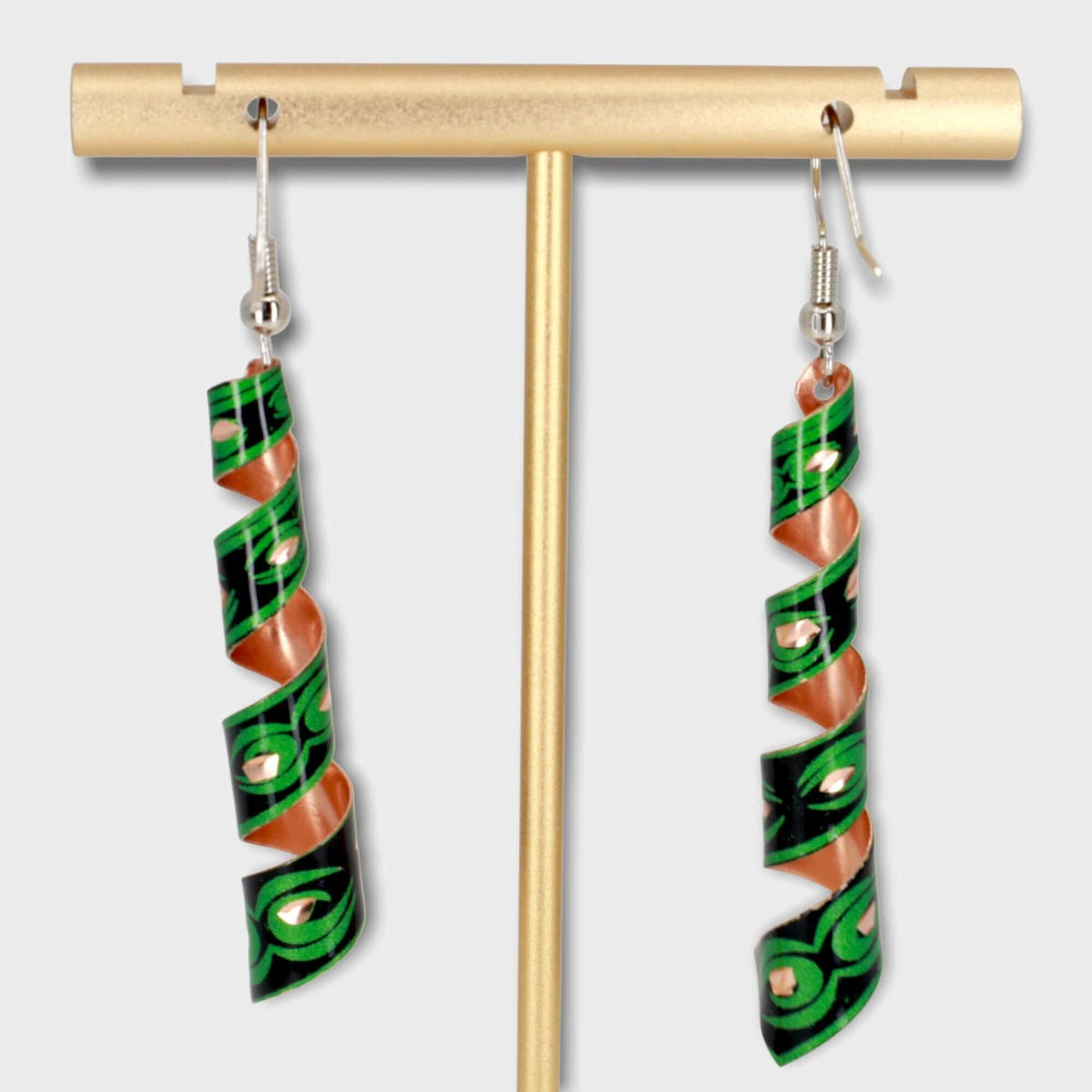 Handcrafted artisan green auger copper earrings shown next to a hand for scale