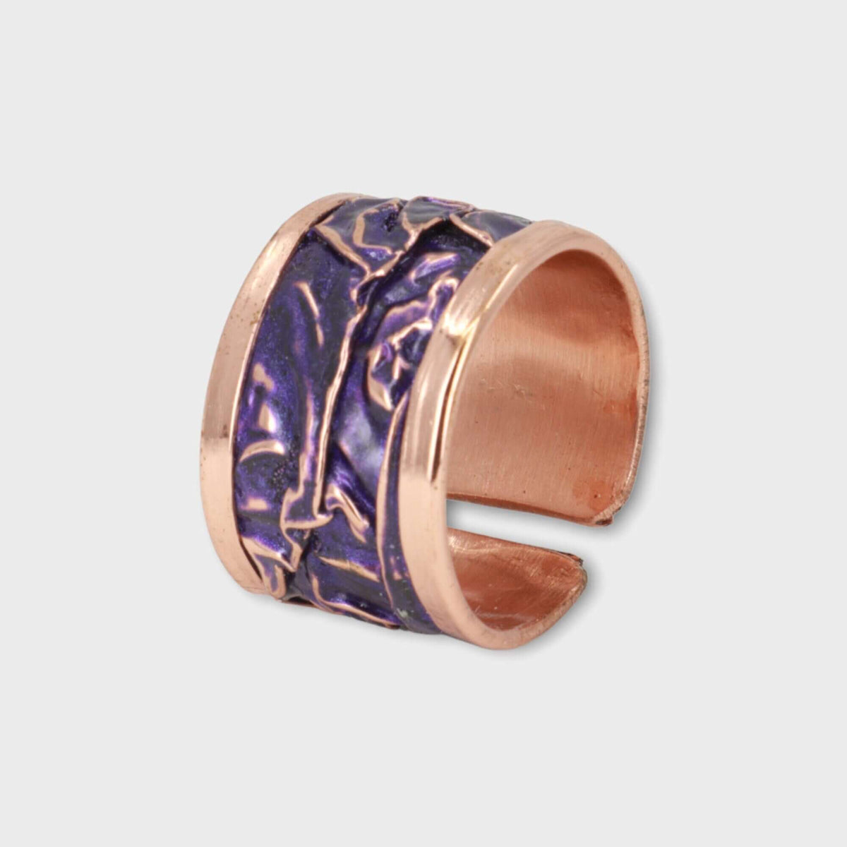 Purple wrinkled copper adjustable ring displayed on a plain background