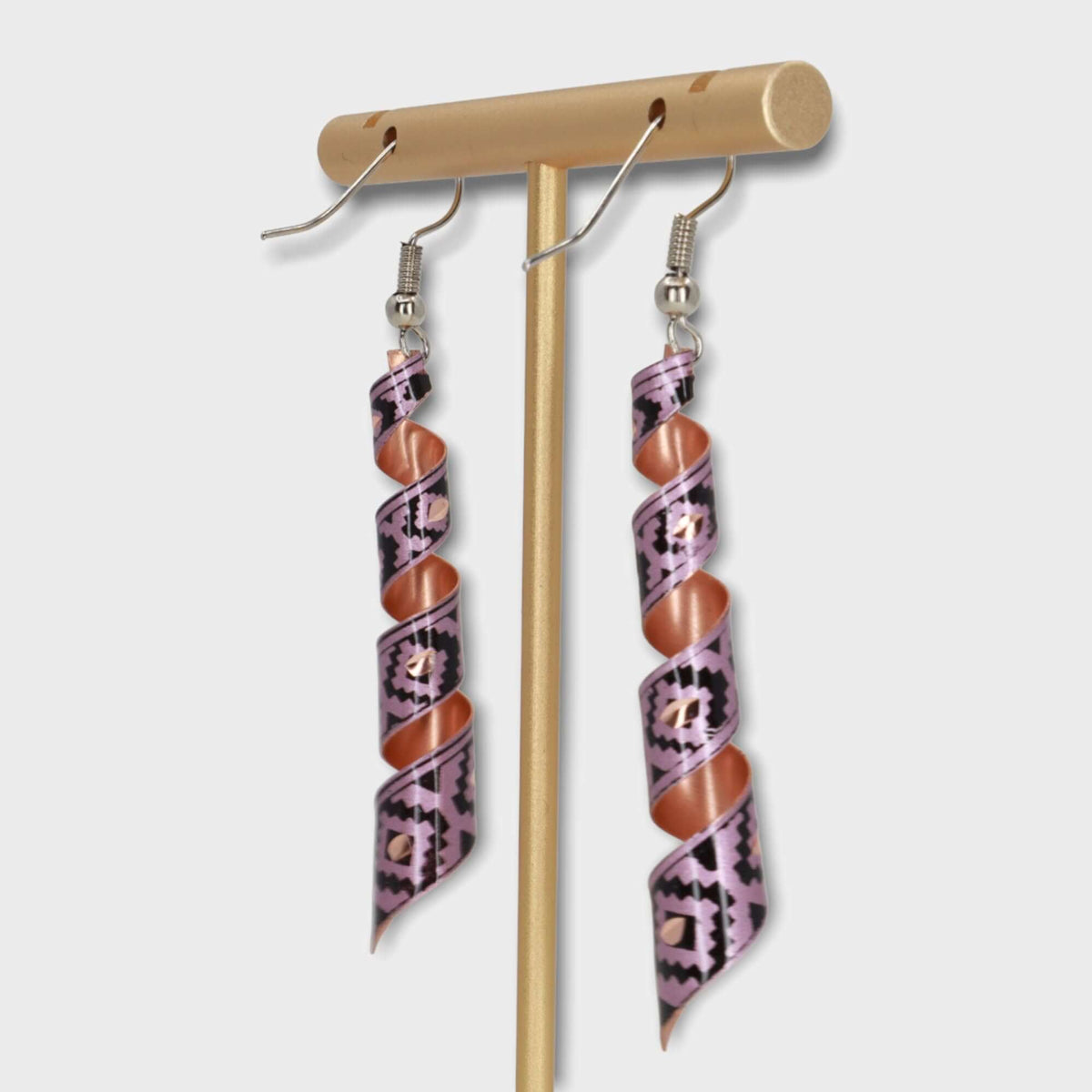 A pair of handcrafted artisan pink auger copper earrings laid flat