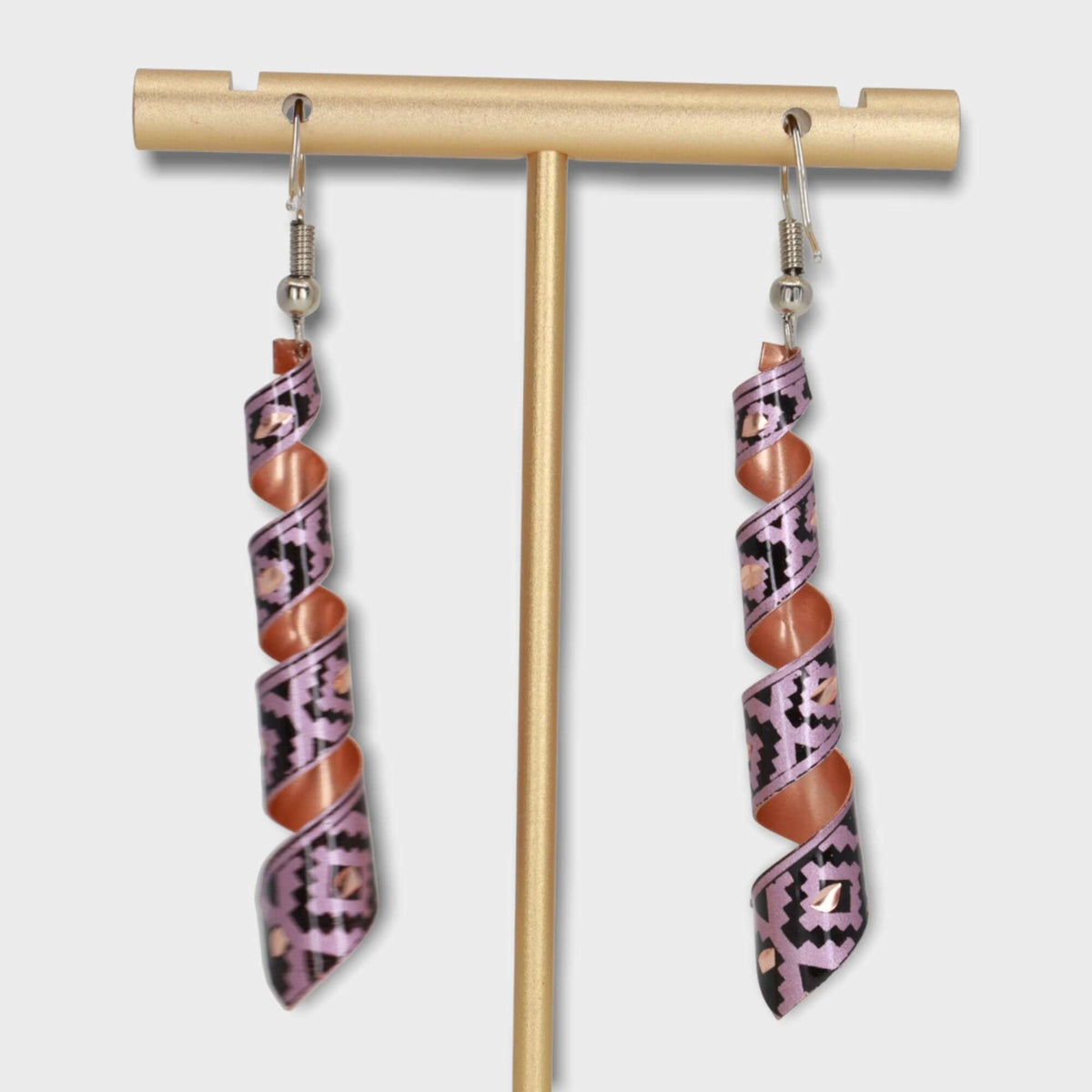 Top-down view of handcrafted artisan pink auger copper earrings