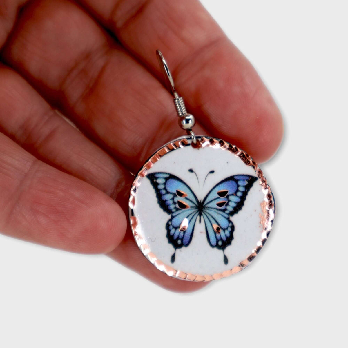 Handcrafted butterfly copper circle earrings displayed on a plain background