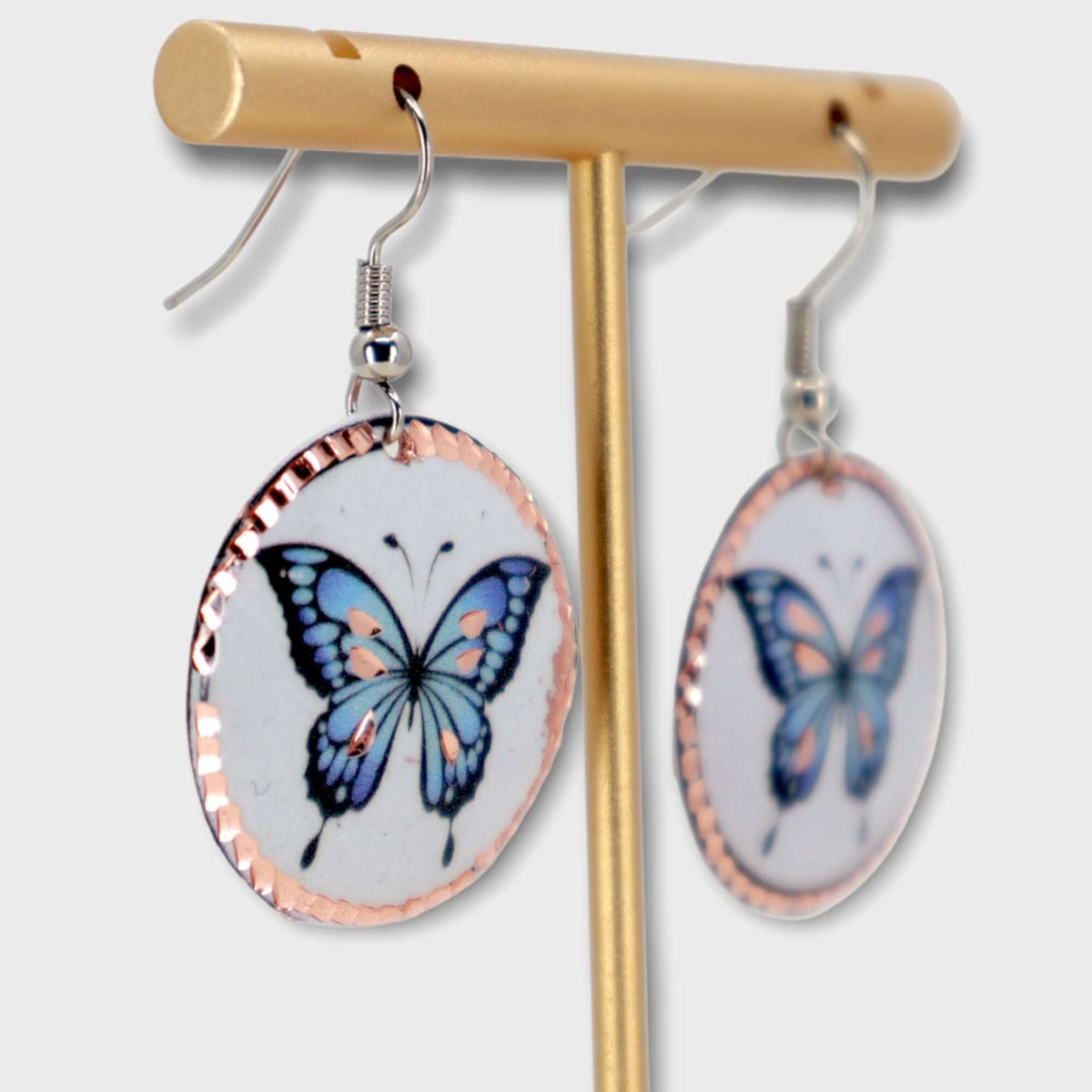 Top-down view of handcrafted butterfly copper circle earrings