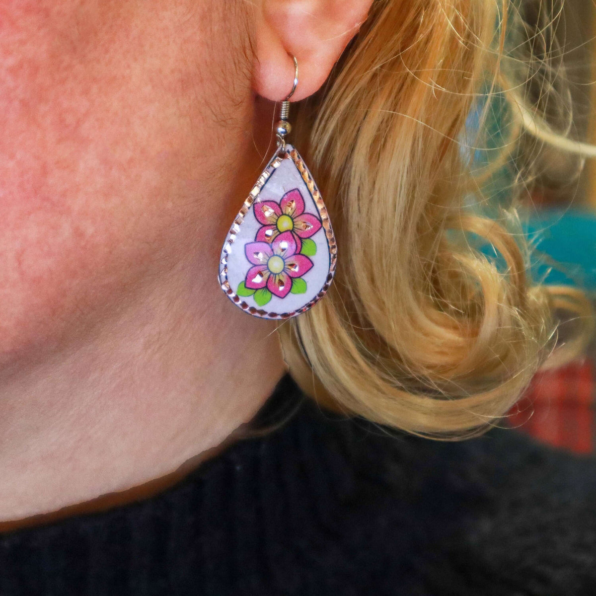 Top-down view of handcrafted pink flower copper drop earrings