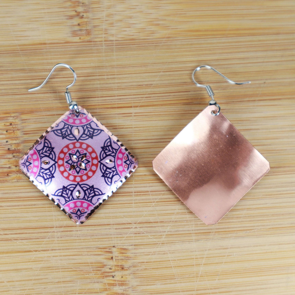 Handcrafted artisan pink copper square earrings displayed on a plain background