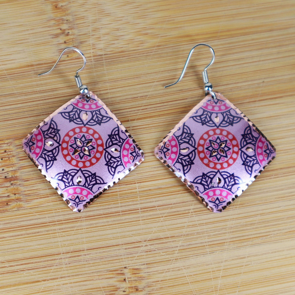 Top-down view of handcrafted artisan pink copper square earrings